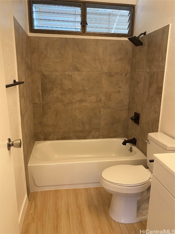 full bathroom featuring vanity, wood-type flooring, tiled shower / bath combo, and toilet