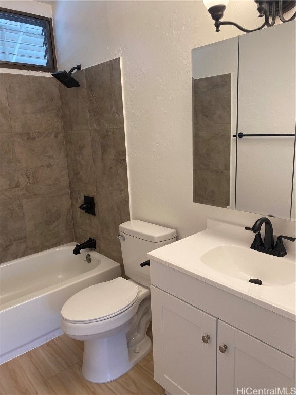 full bathroom with hardwood / wood-style floors, vanity, toilet, and tiled shower / bath