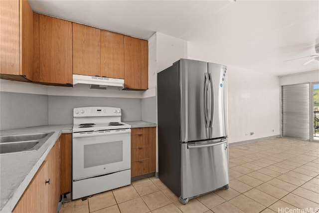 kitchen with white electric range oven, stainless steel fridge, sink, and light tile patterned flooring