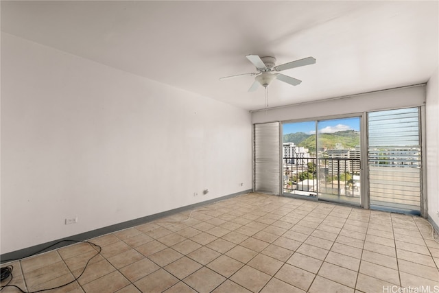 spare room with ceiling fan and light tile patterned flooring