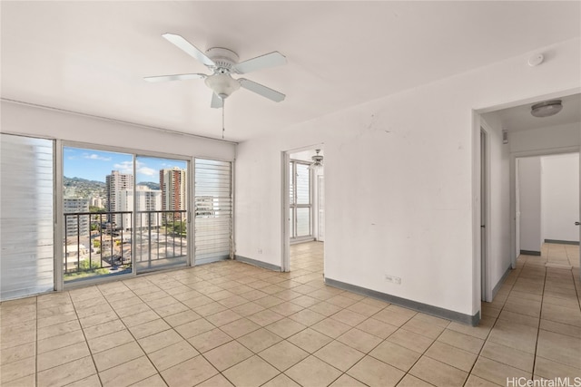 empty room with ceiling fan and light tile patterned flooring