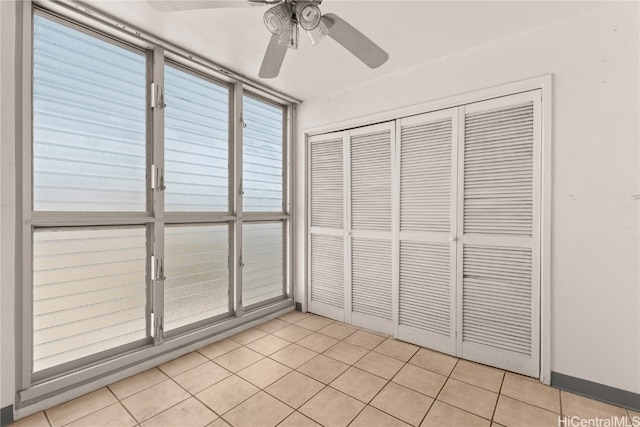 unfurnished sunroom with ceiling fan