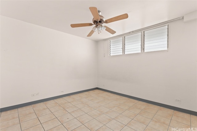 tiled empty room featuring ceiling fan