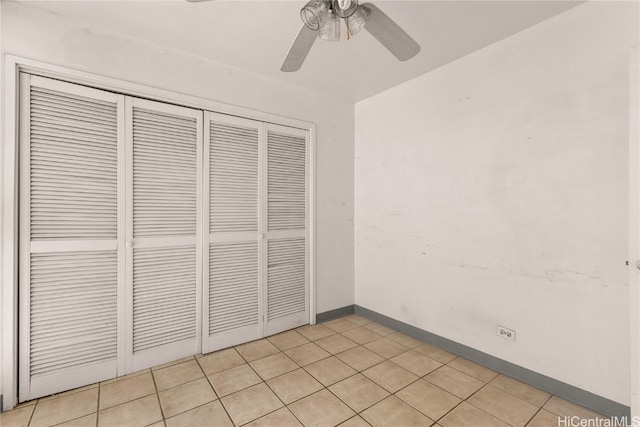 unfurnished bedroom with ceiling fan, a closet, and light tile patterned flooring