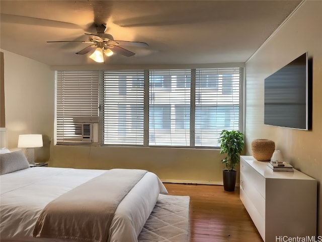 bedroom with hardwood / wood-style flooring, multiple windows, and ceiling fan