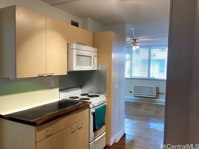 kitchen featuring light brown cabinetry, radiator heating unit, dark hardwood / wood-style floors, and white appliances