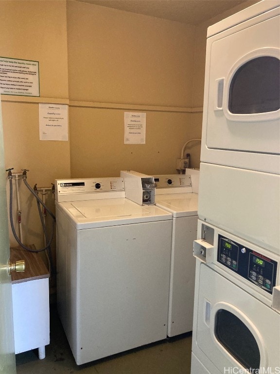 washroom featuring stacked washer and dryer and washer and clothes dryer