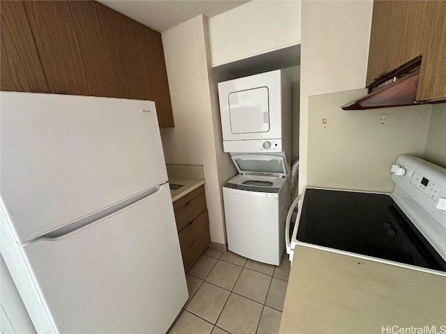 laundry room featuring light tile patterned flooring and stacked washer / drying machine