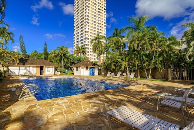 view of pool featuring an outbuilding and a patio