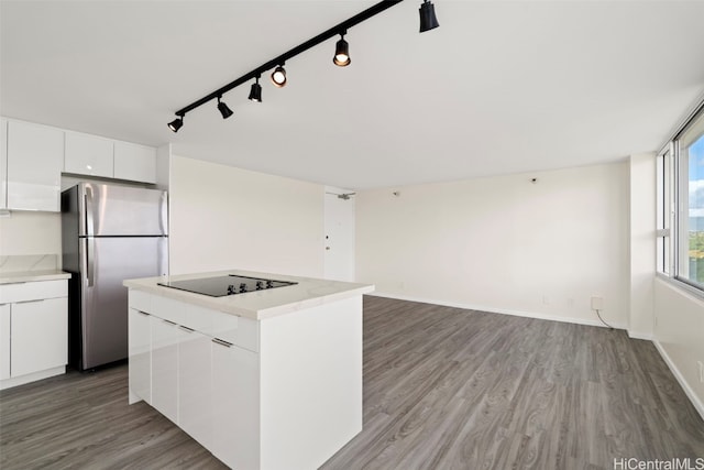 kitchen with black electric cooktop, wood-type flooring, white cabinetry, a center island, and stainless steel refrigerator