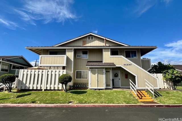 view of front facade featuring a balcony and a front lawn