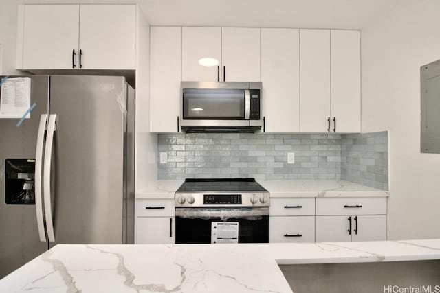 kitchen with backsplash, stainless steel appliances, light stone counters, and white cabinetry