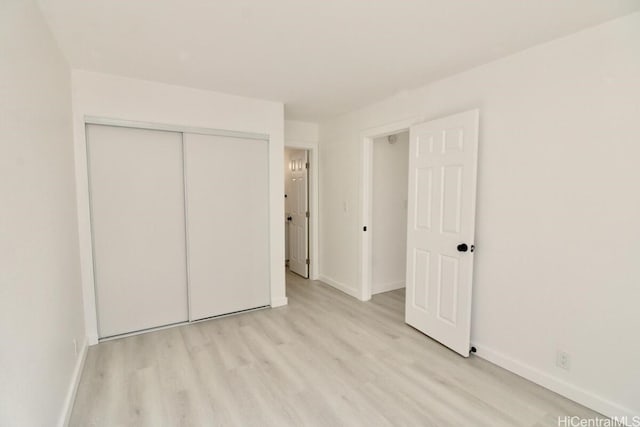 unfurnished bedroom with a closet and light hardwood / wood-style floors