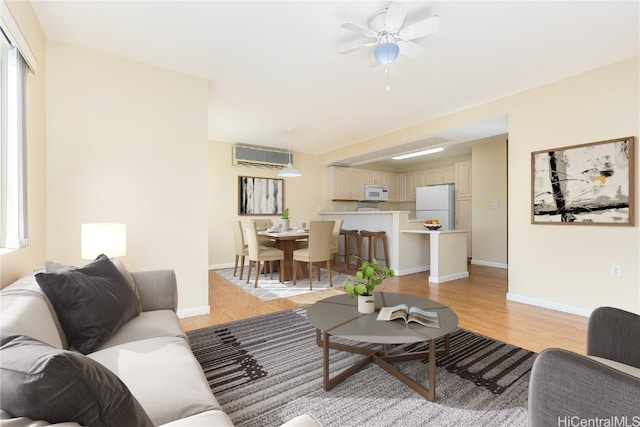 living room with ceiling fan, light wood-type flooring, and a wall mounted AC