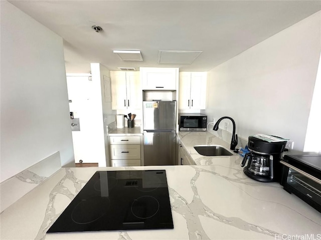 kitchen featuring sink, white cabinetry, light stone counters, kitchen peninsula, and stainless steel appliances