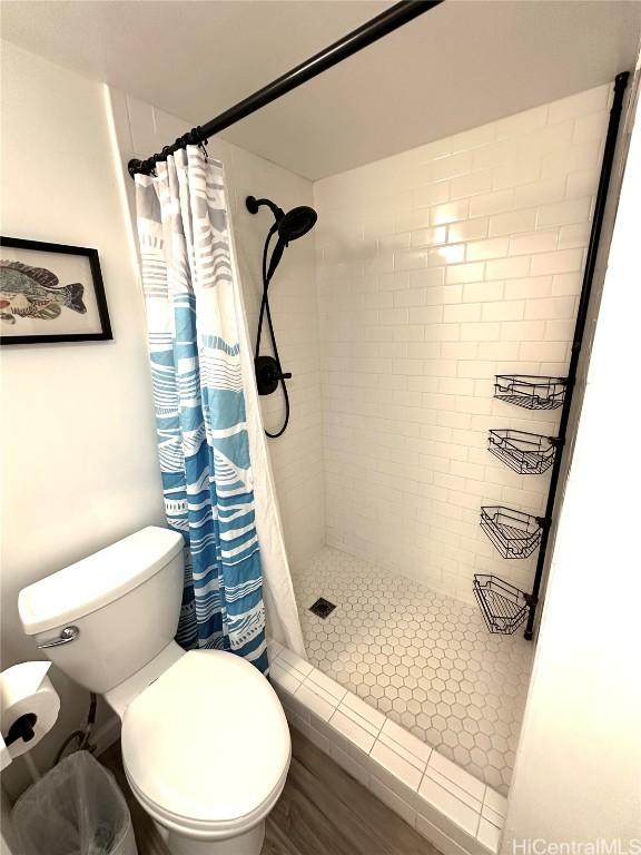 bathroom featuring toilet and a shower with shower curtain