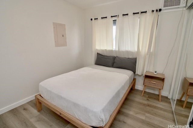 bedroom featuring light wood-type flooring and electric panel