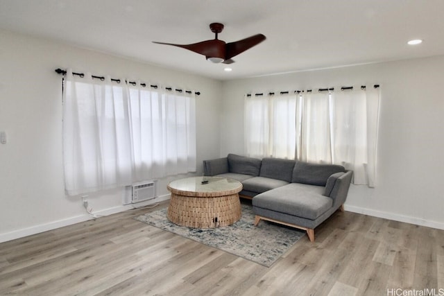 living room with light hardwood / wood-style floors and ceiling fan