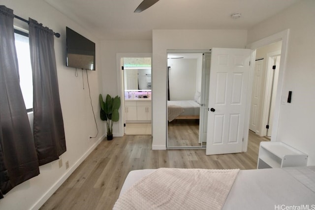 bedroom with ceiling fan, connected bathroom, and light hardwood / wood-style flooring