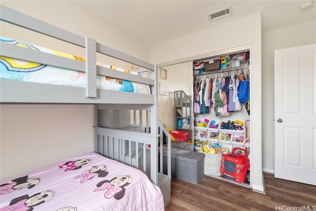 bedroom with dark wood-type flooring and a closet