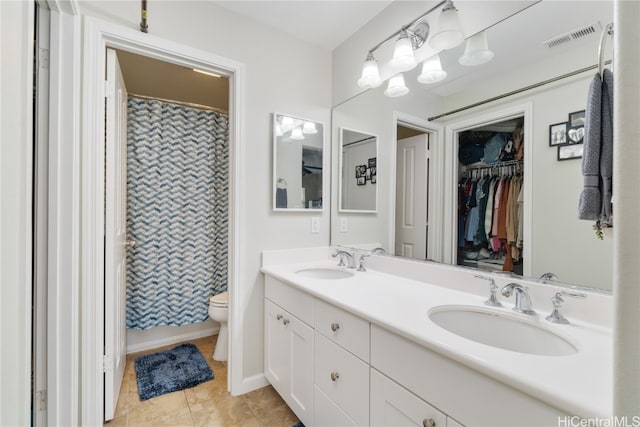 bathroom with toilet, a shower with curtain, vanity, and tile patterned floors