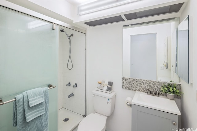 bathroom with a shower with door, vanity, and toilet