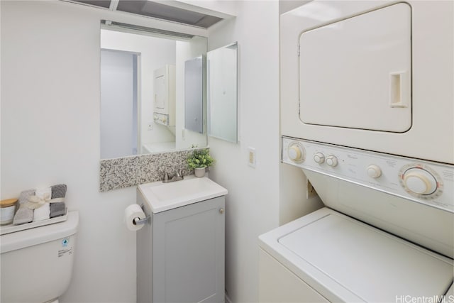 clothes washing area featuring stacked washing maching and dryer and sink