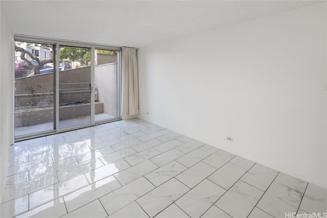 unfurnished room featuring floor to ceiling windows