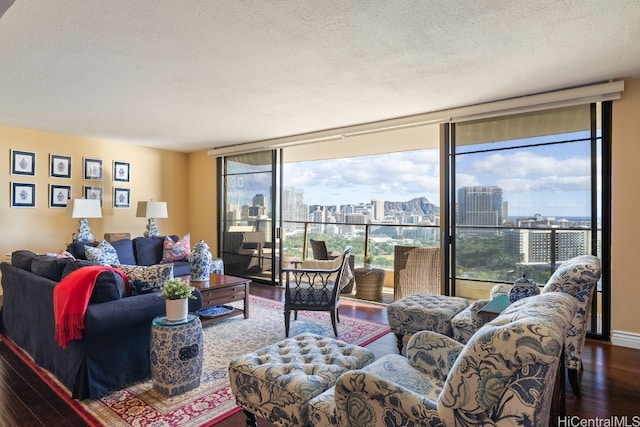 living room with hardwood / wood-style floors, a textured ceiling, and a wall of windows