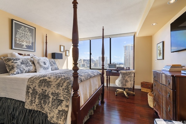 bedroom with dark hardwood / wood-style floors, expansive windows, and a textured ceiling