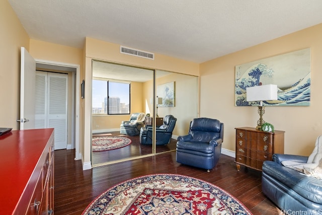 living area with dark hardwood / wood-style flooring and a textured ceiling