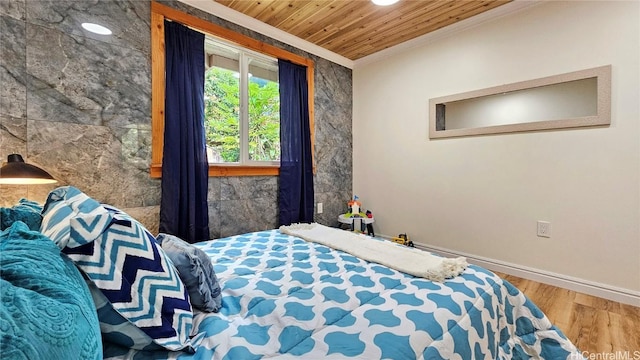 bedroom featuring wooden ceiling, crown molding, wood finished floors, and baseboards