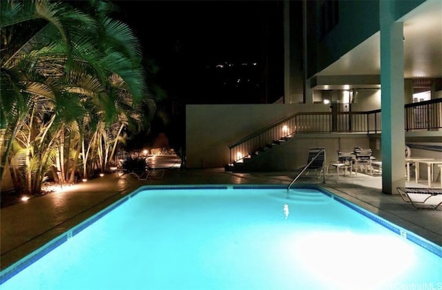 pool at night with a patio area