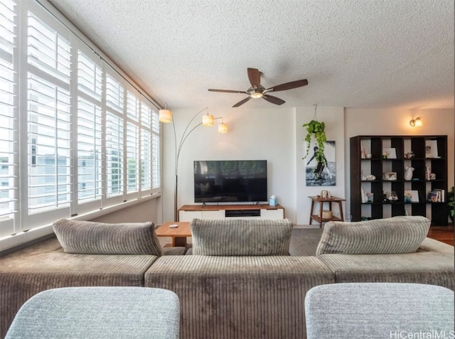 living room featuring ceiling fan and a textured ceiling