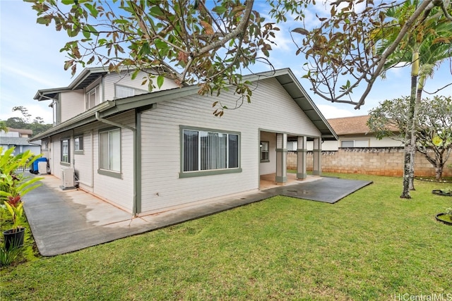 back of house with a lawn and a patio area