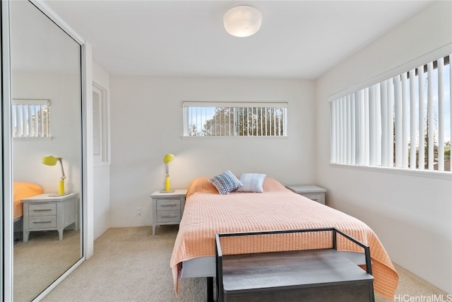 carpeted bedroom featuring multiple windows and a closet