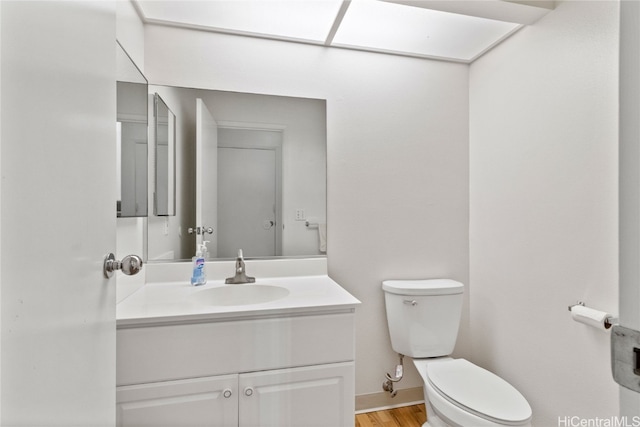 bathroom with vanity, hardwood / wood-style flooring, and toilet