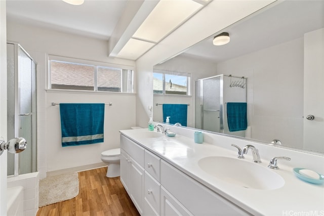 bathroom with wood-type flooring, vanity, toilet, and walk in shower