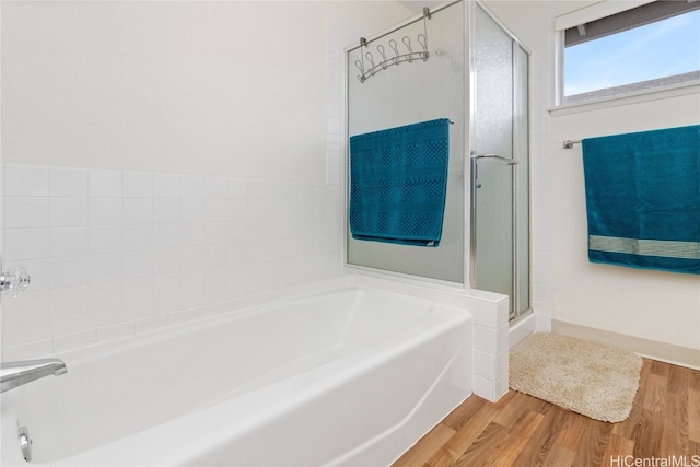 bathroom featuring separate shower and tub and wood-type flooring