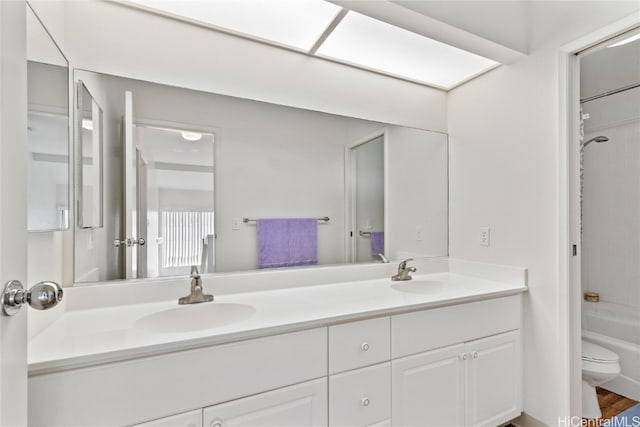 full bathroom featuring hardwood / wood-style floors, vanity, toilet, and shower / tub combination