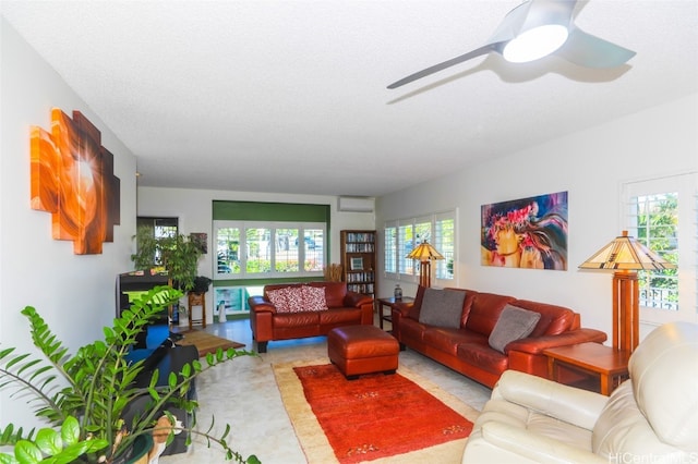 living room with ceiling fan and a textured ceiling