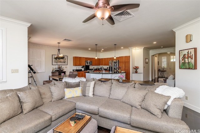 living room featuring ceiling fan with notable chandelier and ornamental molding