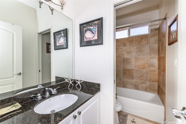 full bathroom featuring vanity, tiled shower / bath combo, and toilet