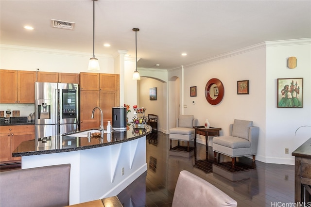 kitchen with stainless steel fridge, decorative light fixtures, ornamental molding, and sink