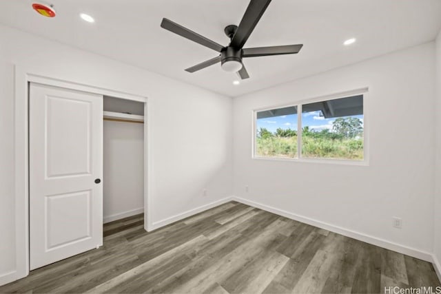 unfurnished bedroom featuring ceiling fan, dark wood-type flooring, and a closet