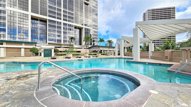 view of swimming pool featuring a hot tub