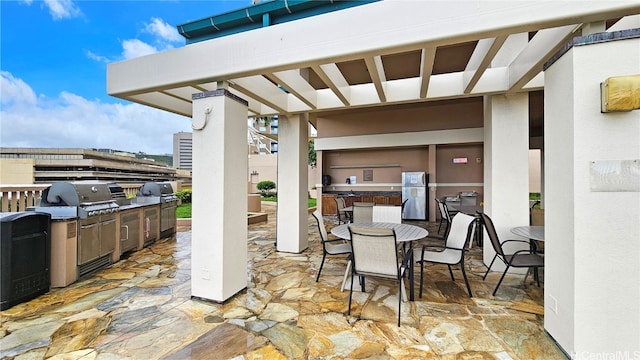 view of patio featuring a pergola, area for grilling, and exterior kitchen