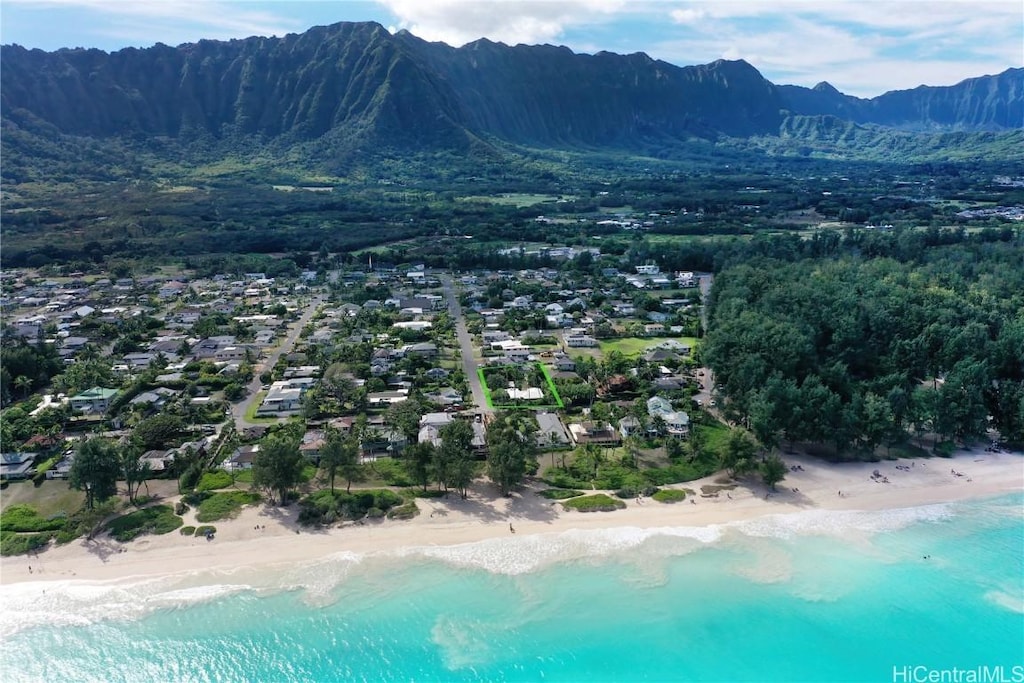 birds eye view of property featuring a view of the beach and a water and mountain view