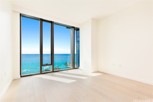 unfurnished room featuring a water view and light hardwood / wood-style flooring