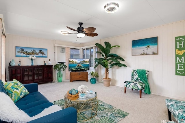 living room with carpet, ceiling fan, and wooden walls